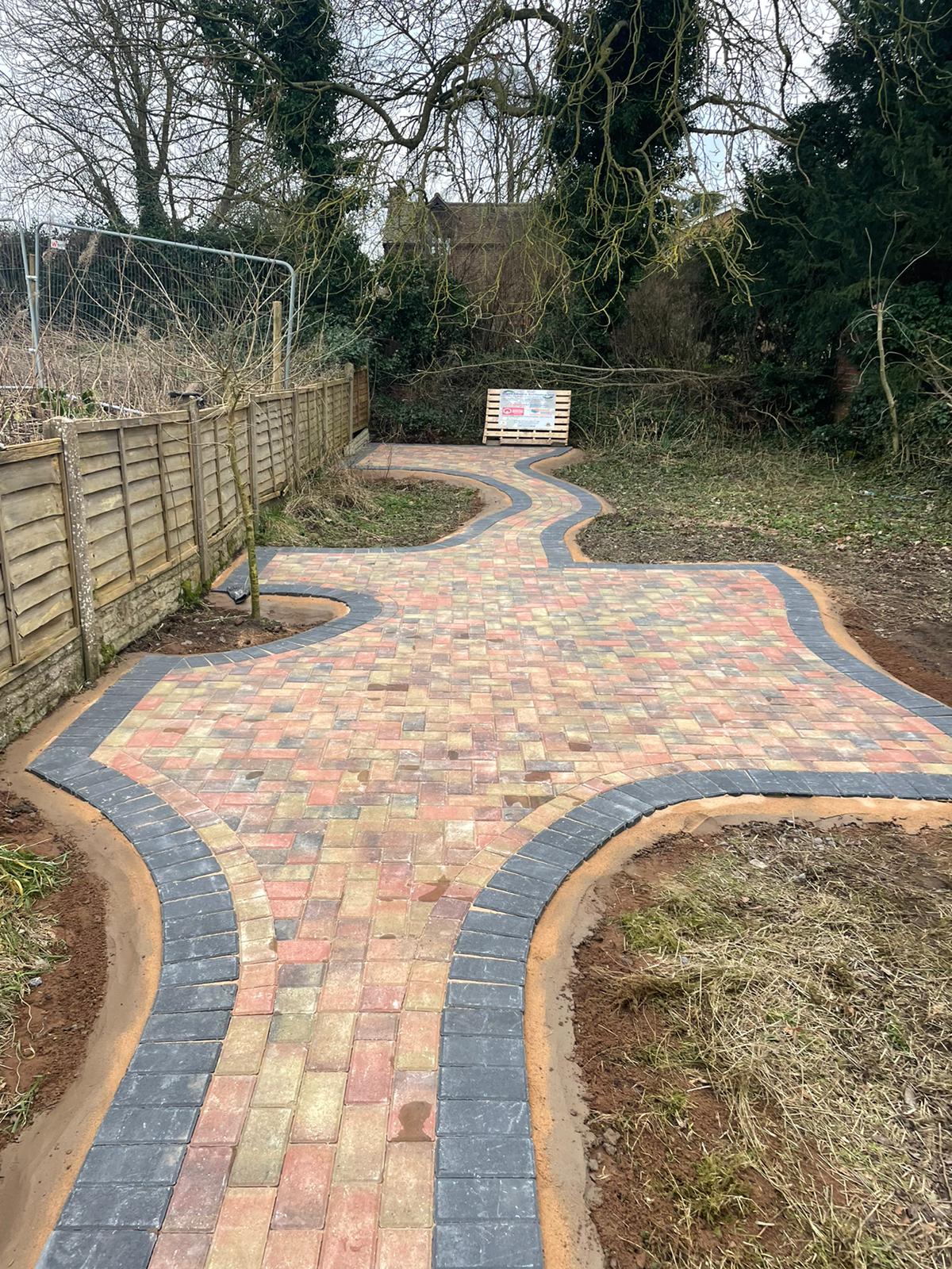 Curved block paved garden path with charcoal edging